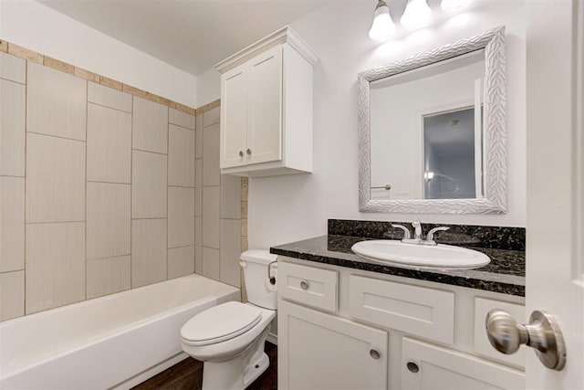 bathroom with washtub / shower combination, toilet, vanity, and wood finished floors