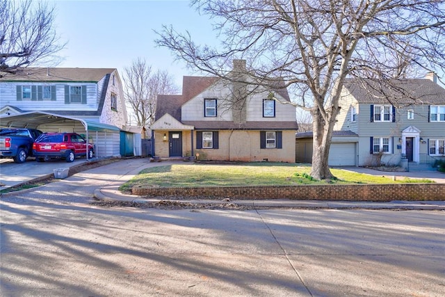 view of front of home with brick siding, a front yard, a chimney, a garage, and driveway