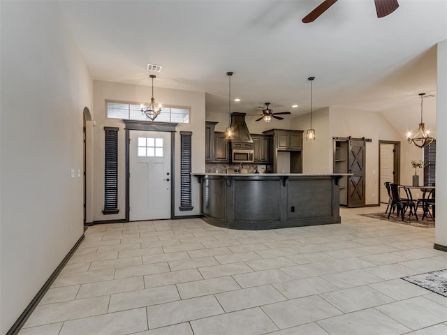 foyer featuring visible vents, ceiling fan with notable chandelier, a barn door, arched walkways, and light tile patterned floors