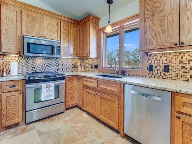 kitchen with pendant lighting, tasteful backsplash, appliances with stainless steel finishes, and a sink