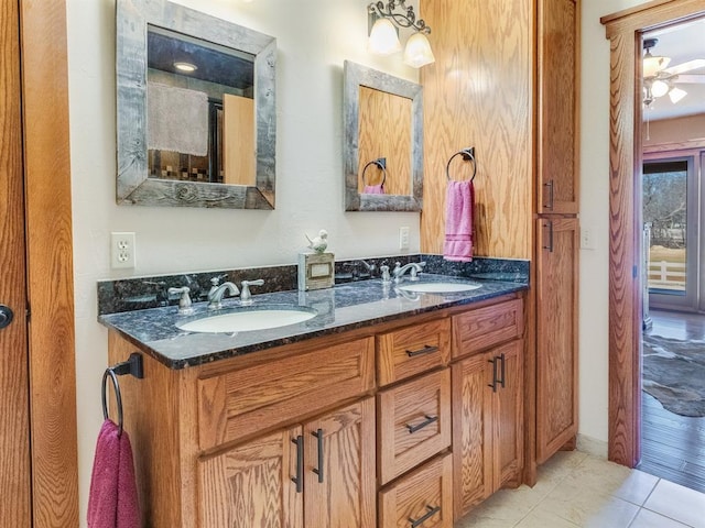 bathroom featuring tile patterned flooring, double vanity, ceiling fan, and a sink