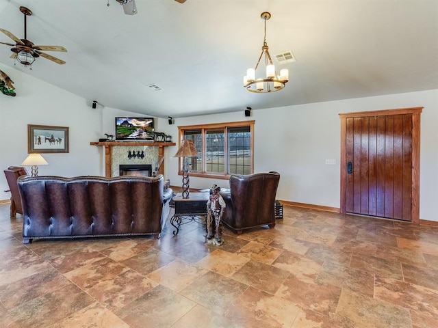 living room with visible vents, baseboards, lofted ceiling, ceiling fan with notable chandelier, and a tile fireplace