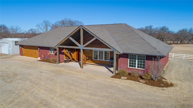 view of front facade featuring brick siding and fence