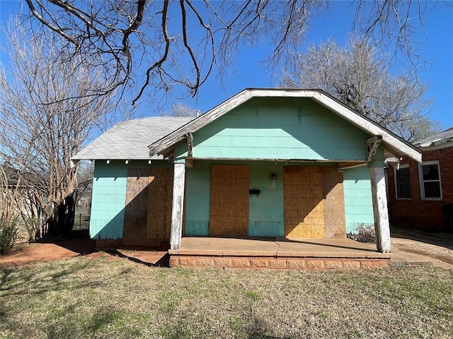 view of front of home featuring roof with shingles and a front lawn