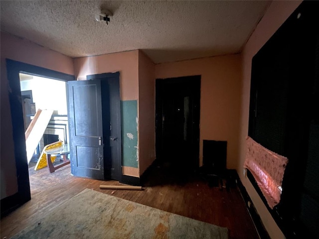 spare room featuring a textured ceiling and wood finished floors