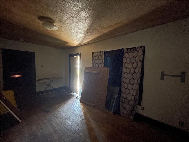 unfurnished room featuring wood finished floors and a textured ceiling