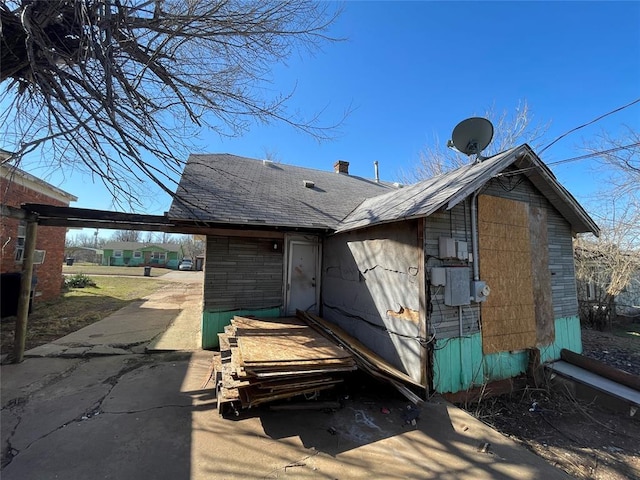 rear view of house featuring a shingled roof