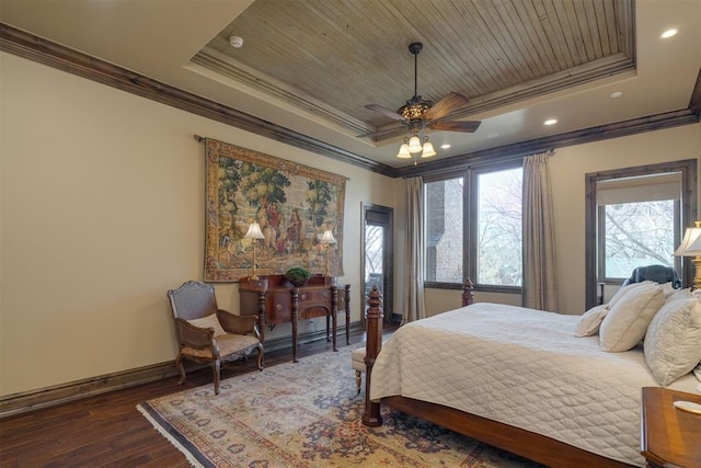 bedroom with a tray ceiling, wood finished floors, and crown molding