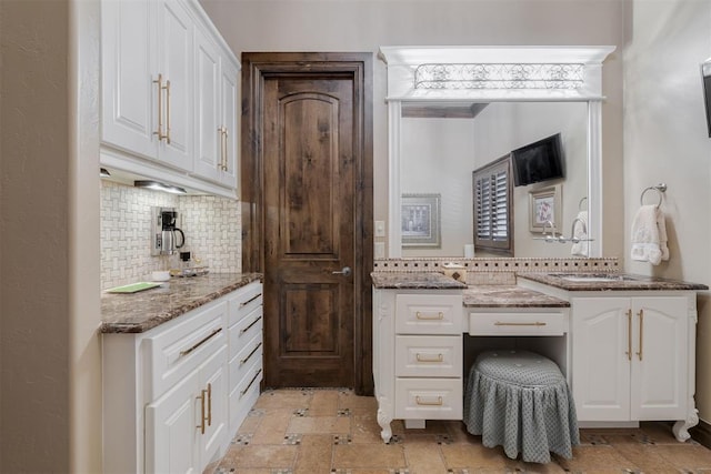 bathroom with stone tile floors, tasteful backsplash, and vanity