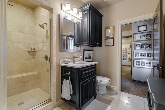 bathroom with tile patterned flooring, baseboards, toilet, a stall shower, and vanity