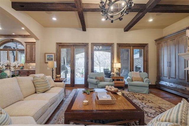 living area with beam ceiling, a notable chandelier, coffered ceiling, dark wood finished floors, and french doors