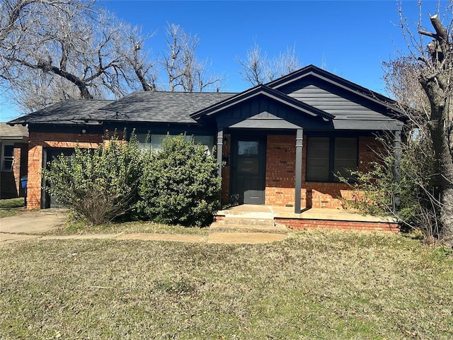 view of front of house featuring brick siding, concrete driveway, a front lawn, and a garage