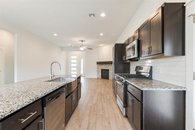 kitchen featuring visible vents, backsplash, light wood-style flooring, appliances with stainless steel finishes, and a ceiling fan