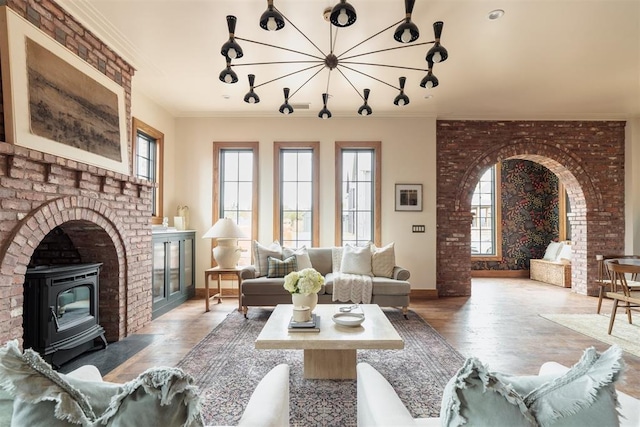 living room with arched walkways, a notable chandelier, crown molding, and wood finished floors