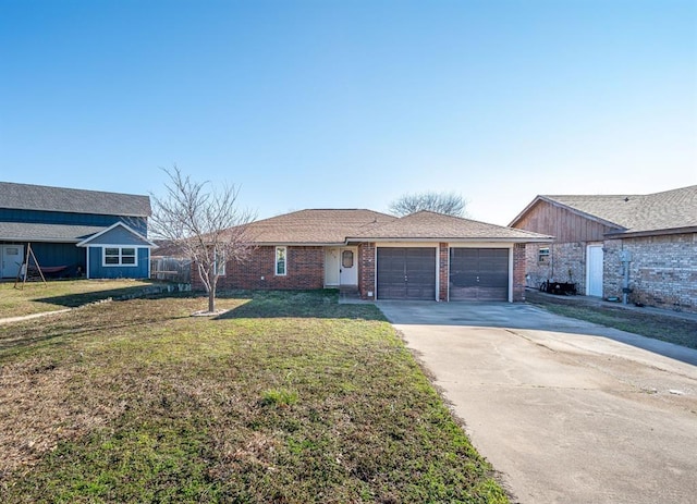 view of front of home featuring a front yard, brick siding, a garage, and driveway