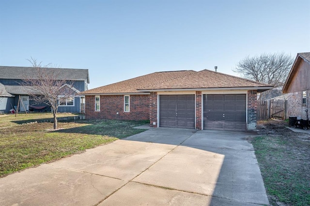 ranch-style home featuring a front lawn, driveway, roof with shingles, an attached garage, and brick siding