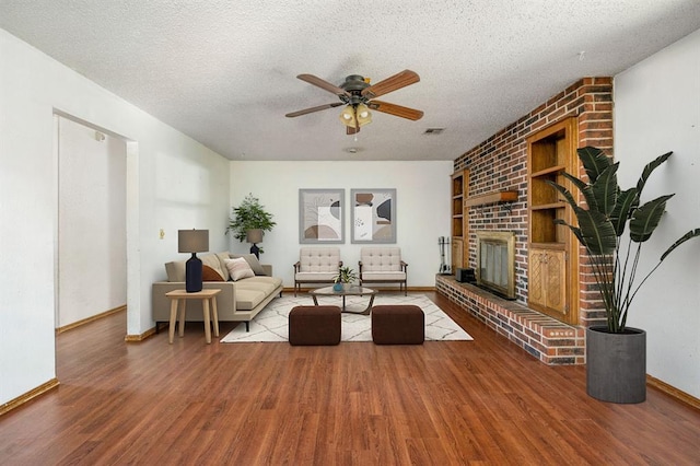 living room featuring wood finished floors, visible vents, and a textured ceiling