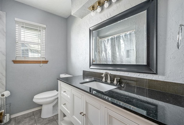 full bathroom featuring vanity, baseboards, tile patterned flooring, toilet, and a textured wall