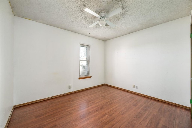 spare room with a ceiling fan, wood finished floors, baseboards, and a textured ceiling