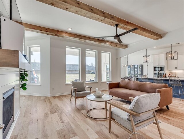 114 Alamosa Rd, Norman, OK 73069 - living area featuring beamed ceiling, light wood-type flooring, a ceiling fan, baseboards, and a chandelier