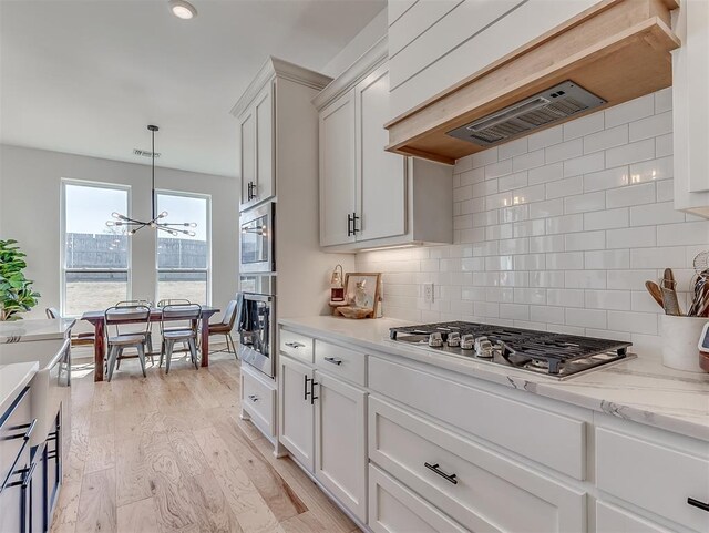 114 Alamosa Rd, Norman, OK 73069 - kitchen featuring appliances with stainless steel finishes, a chandelier, tasteful backsplash, and white cabinetry