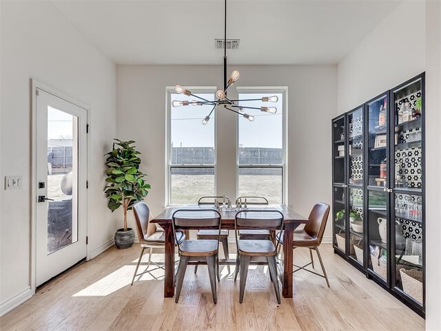 114 Alamosa Rd, Norman, OK 73069 - dining space featuring a chandelier, light wood-style flooring, and baseboards