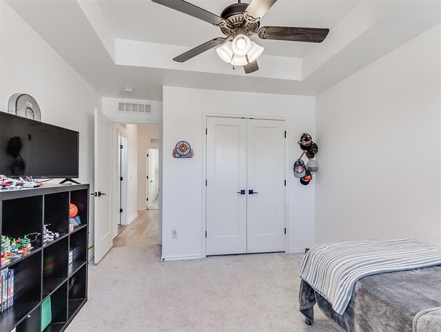 114 Alamosa Rd, Norman, OK 73069 - bedroom with light colored carpet, a closet, baseboards, ceiling fan, and a raised ceiling