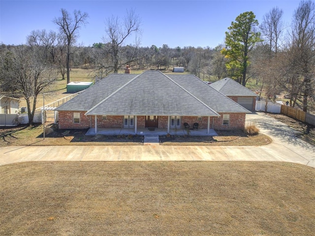 view of front of home featuring a front lawn, fence, and brick siding