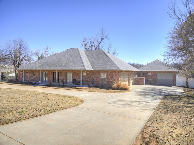 view of front of house with a porch, brick siding, and driveway