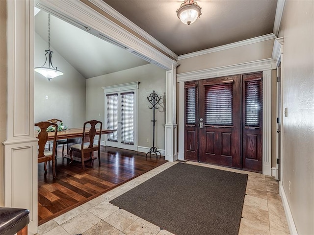 entryway with wood finished floors, crown molding, baseboards, and vaulted ceiling