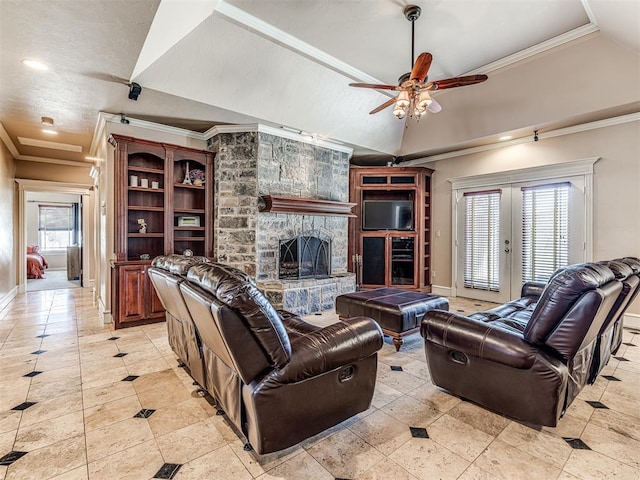 living area with lofted ceiling, a ceiling fan, a stone fireplace, and crown molding