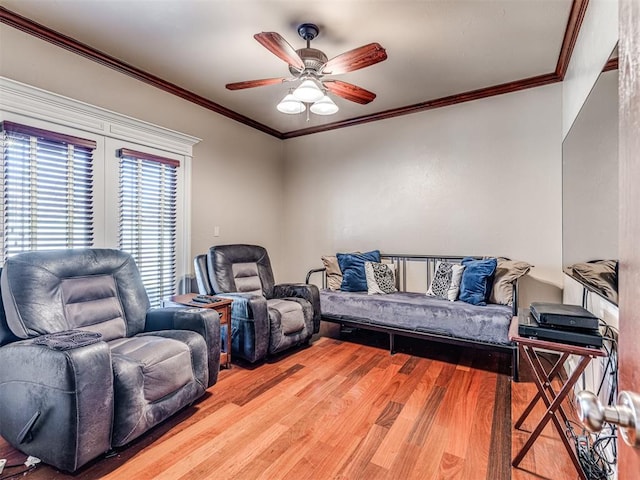 living room with ceiling fan, wood finished floors, and crown molding