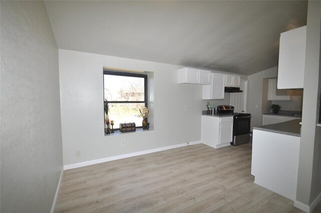 2121 Memphis Dr, Norman, OK 73071 - kitchen with dark countertops, under cabinet range hood, light wood-style floors, electric range, and white cabinetry