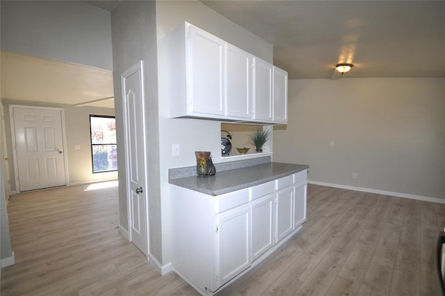 2121 Memphis Dr, Norman, OK 73071 - kitchen featuring dark countertops, white cabinets, light wood-type flooring, and baseboards