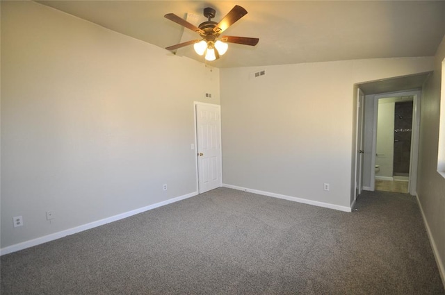 2121 Memphis Dr, Norman, OK 73071 - empty room featuring visible vents, a ceiling fan, dark colored carpet, baseboards, and vaulted ceiling