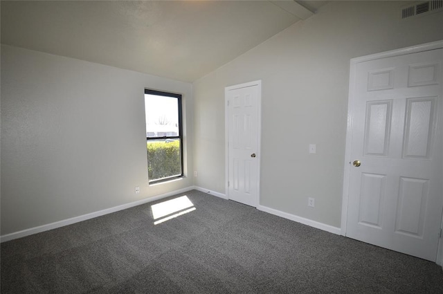 2121 Memphis Dr, Norman, OK 73071 - empty room featuring dark colored carpet, visible vents, baseboards, and vaulted ceiling