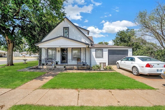 view of front of home with a garage, a porch, concrete driveway, and a front yard