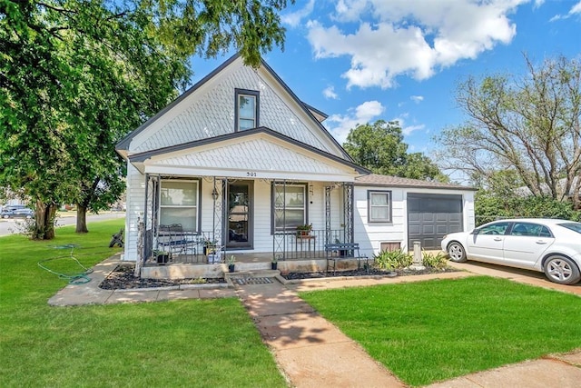 view of front of property featuring a porch, an attached garage, and a front lawn