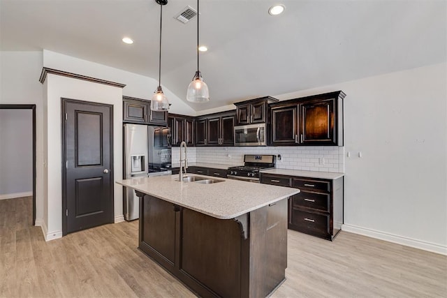 kitchen with tasteful backsplash, light wood finished floors, appliances with stainless steel finishes, and a sink