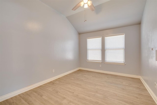 unfurnished room with a ceiling fan, vaulted ceiling, baseboards, and light wood-type flooring