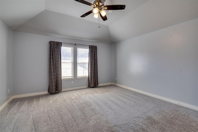 carpeted empty room featuring baseboards, ceiling fan, and vaulted ceiling