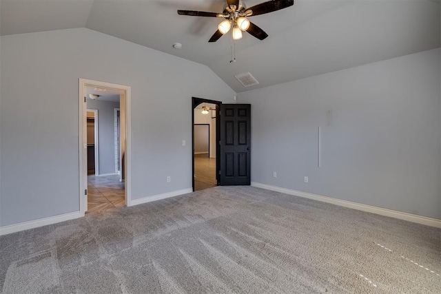 unfurnished bedroom with carpet flooring, ceiling fan, baseboards, and vaulted ceiling