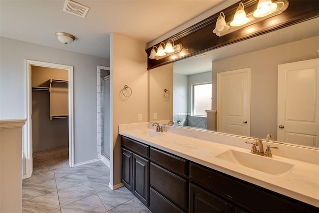 bathroom featuring double vanity, visible vents, a stall shower, and a sink