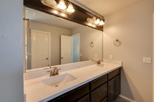 bathroom featuring double vanity, baseboards, visible vents, and a sink