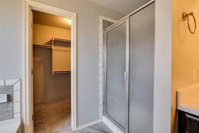 full bathroom featuring a walk in closet and a stall shower