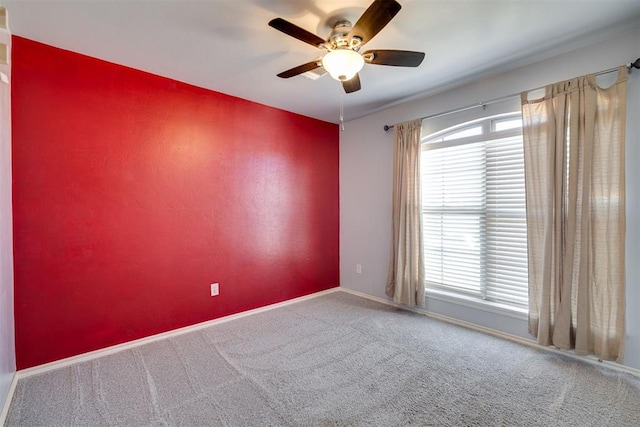 unfurnished room featuring carpet flooring, a ceiling fan, and baseboards