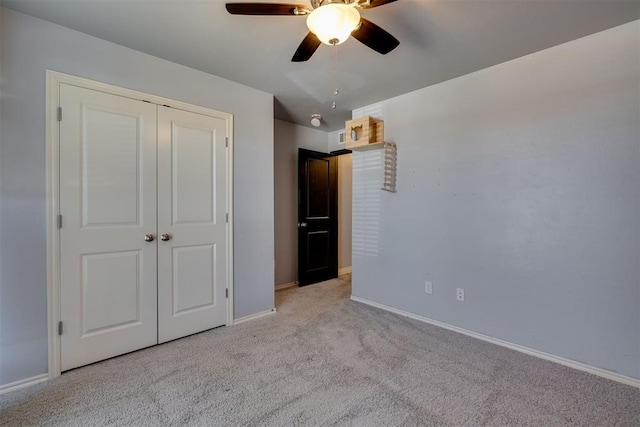 unfurnished bedroom featuring ceiling fan, carpet, a closet, and baseboards