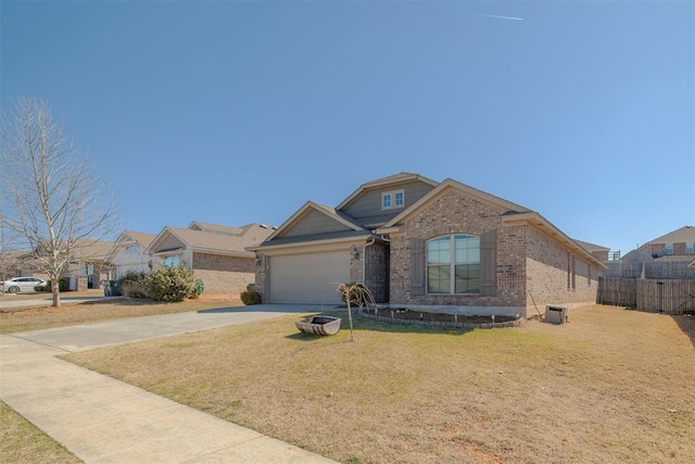 view of front of property featuring a front lawn, driveway, fence, a garage, and brick siding