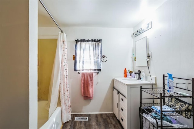 bathroom featuring visible vents, shower / bath combo with shower curtain, wood finished floors, and vanity