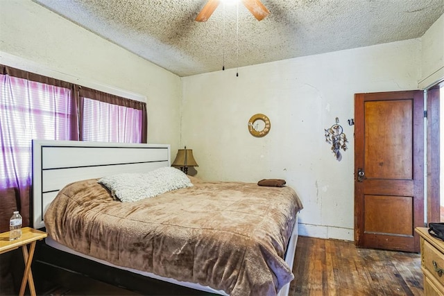 bedroom with baseboards, a textured ceiling, hardwood / wood-style floors, and a ceiling fan